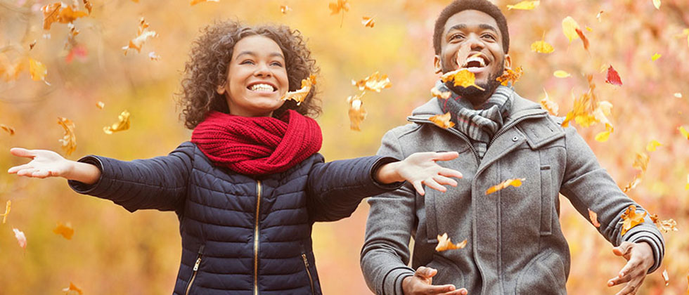 Couple playing in fall leaves