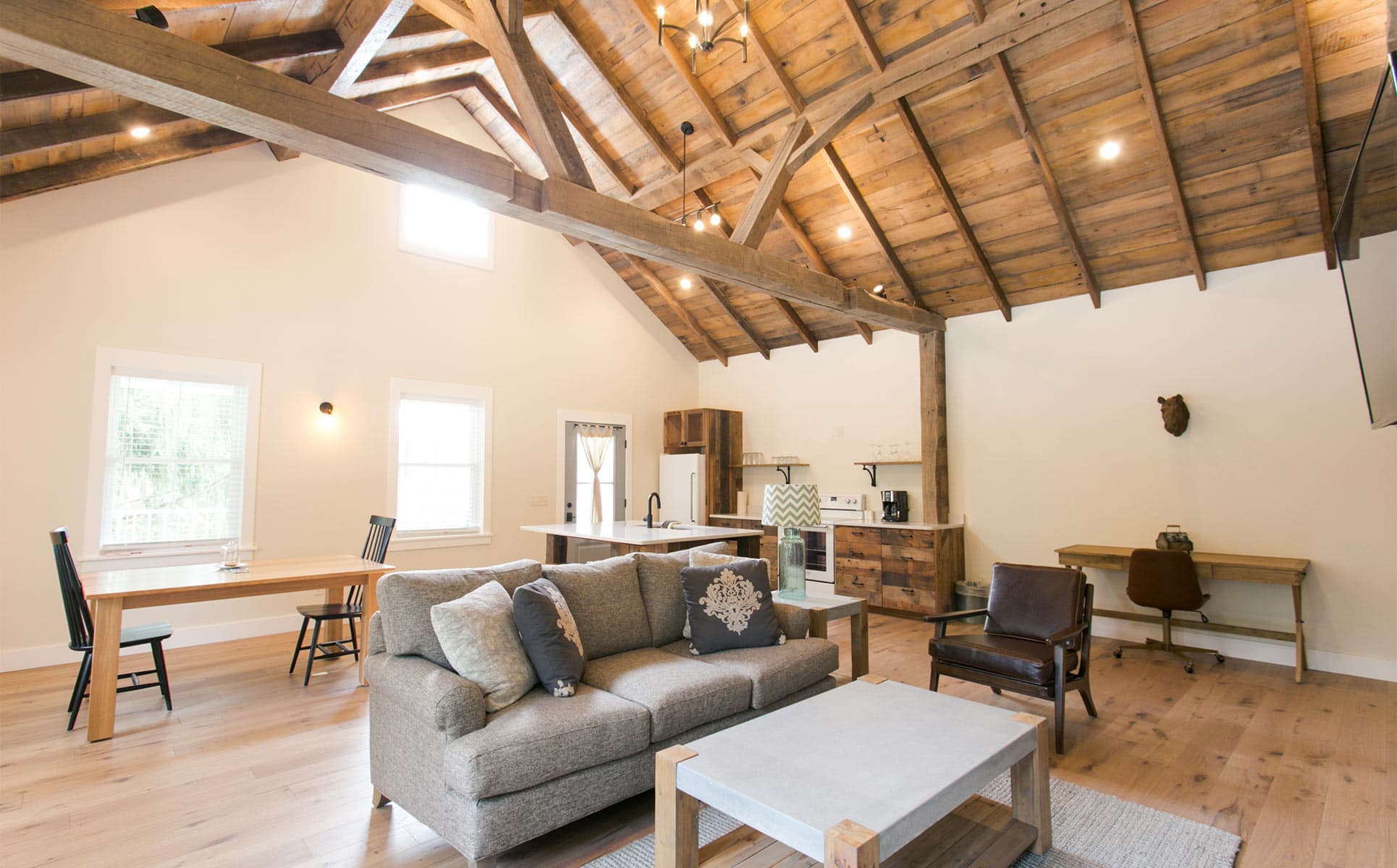 Interior of Barn Suite with couch, chair, desk, kitchen, and dining table