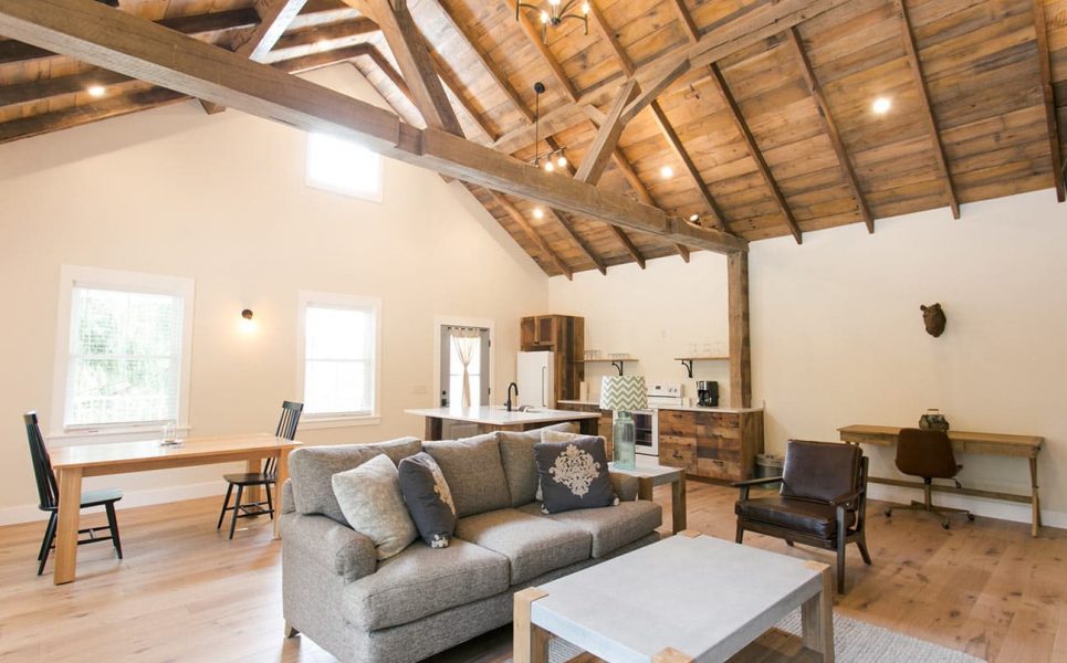 Interior of Barn Suite with couch, chair, desk, kitchen, and dining table