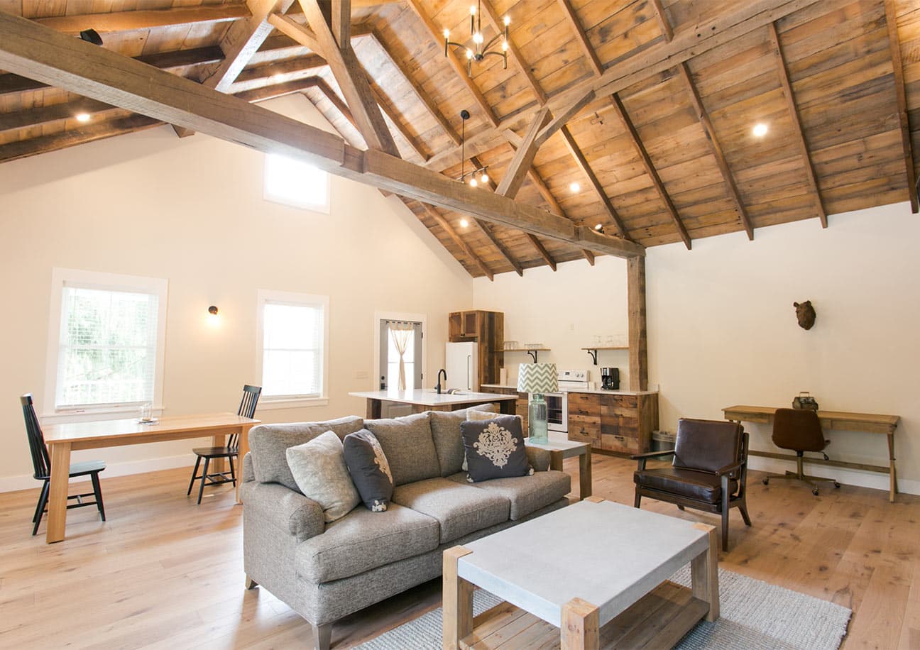 Interior of Barn Suite with couch, chair, desk, kitchen, and dining table