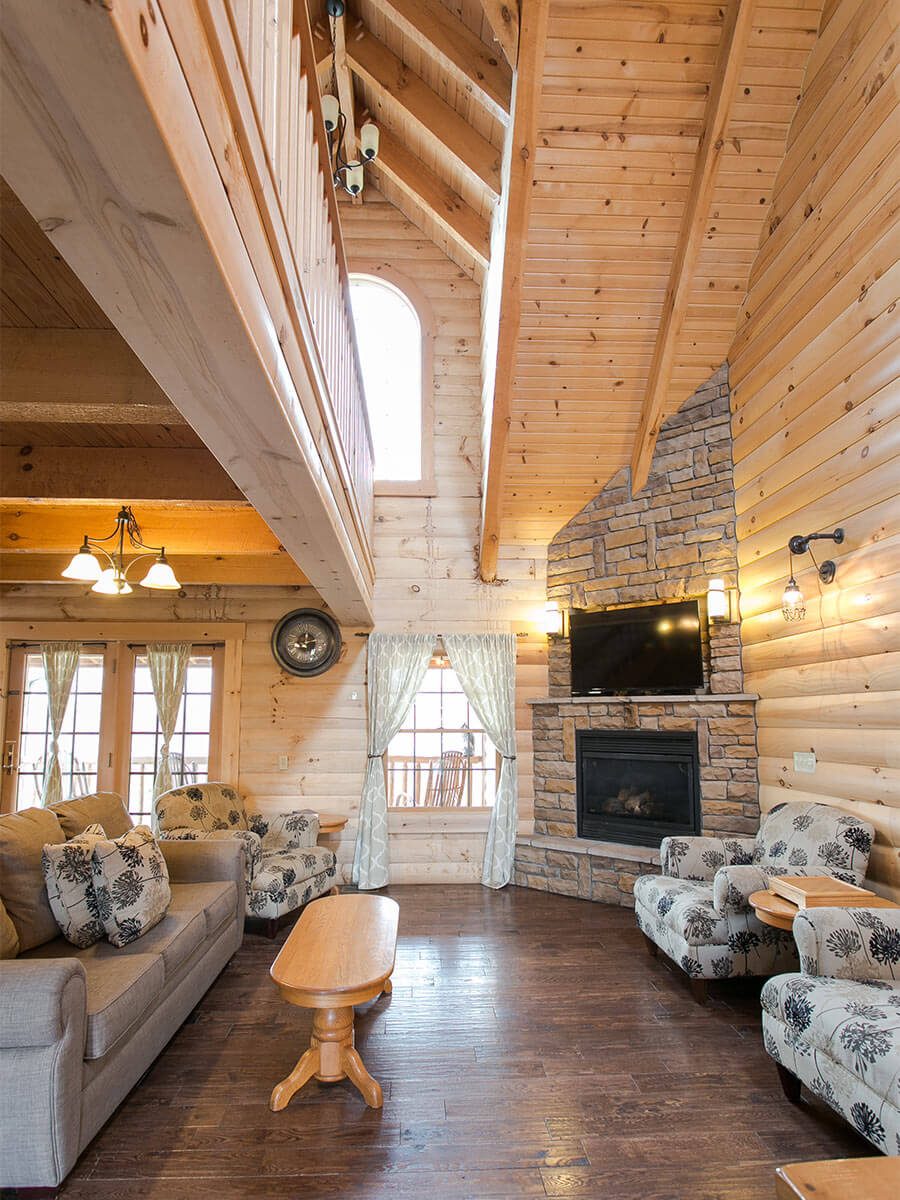 Living Room with couch, 2 chairs, and rock fireplace