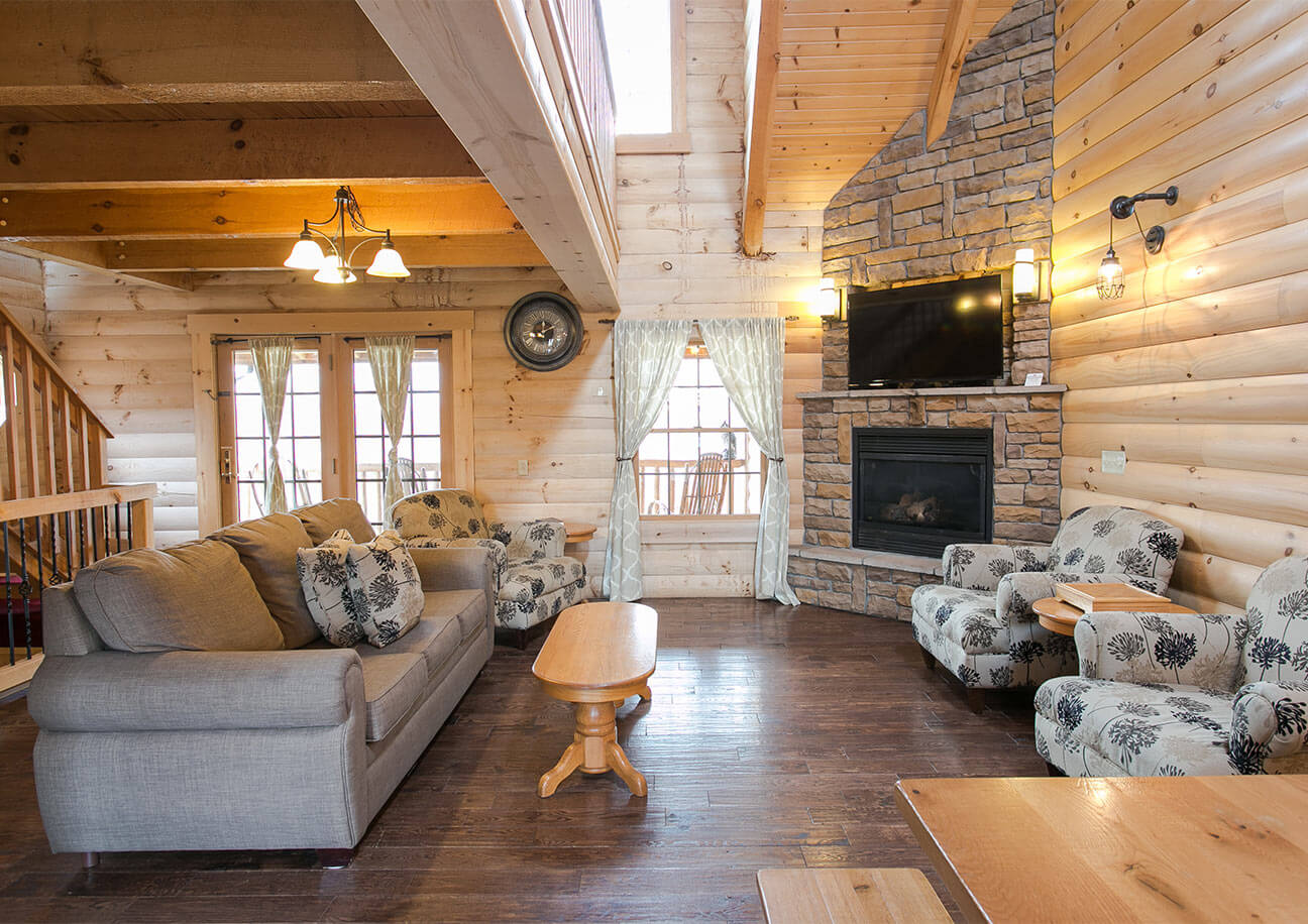 Living Room with couch, 2 chairs, and rock fireplace in Hummingbird Haven