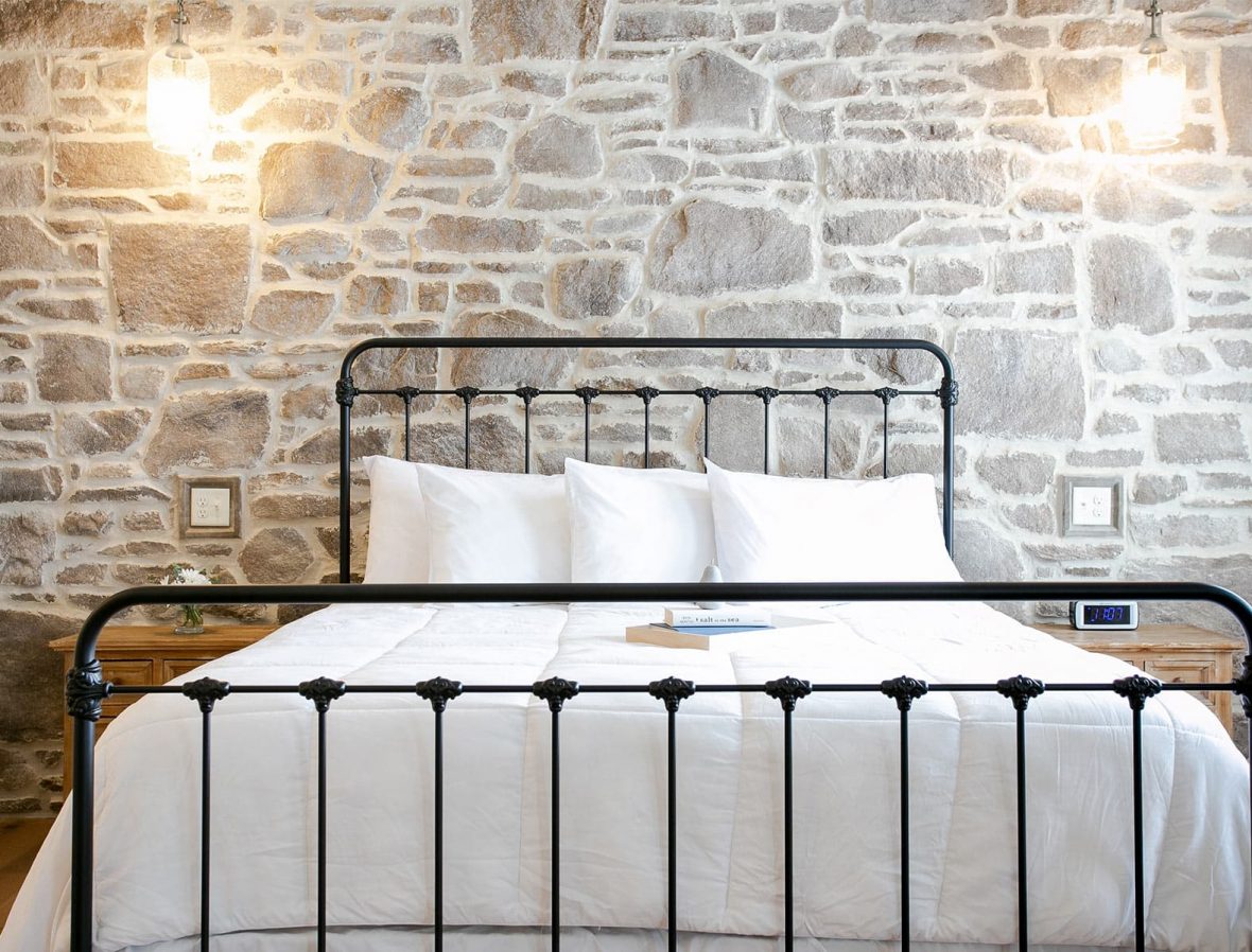 King bed against stone wall