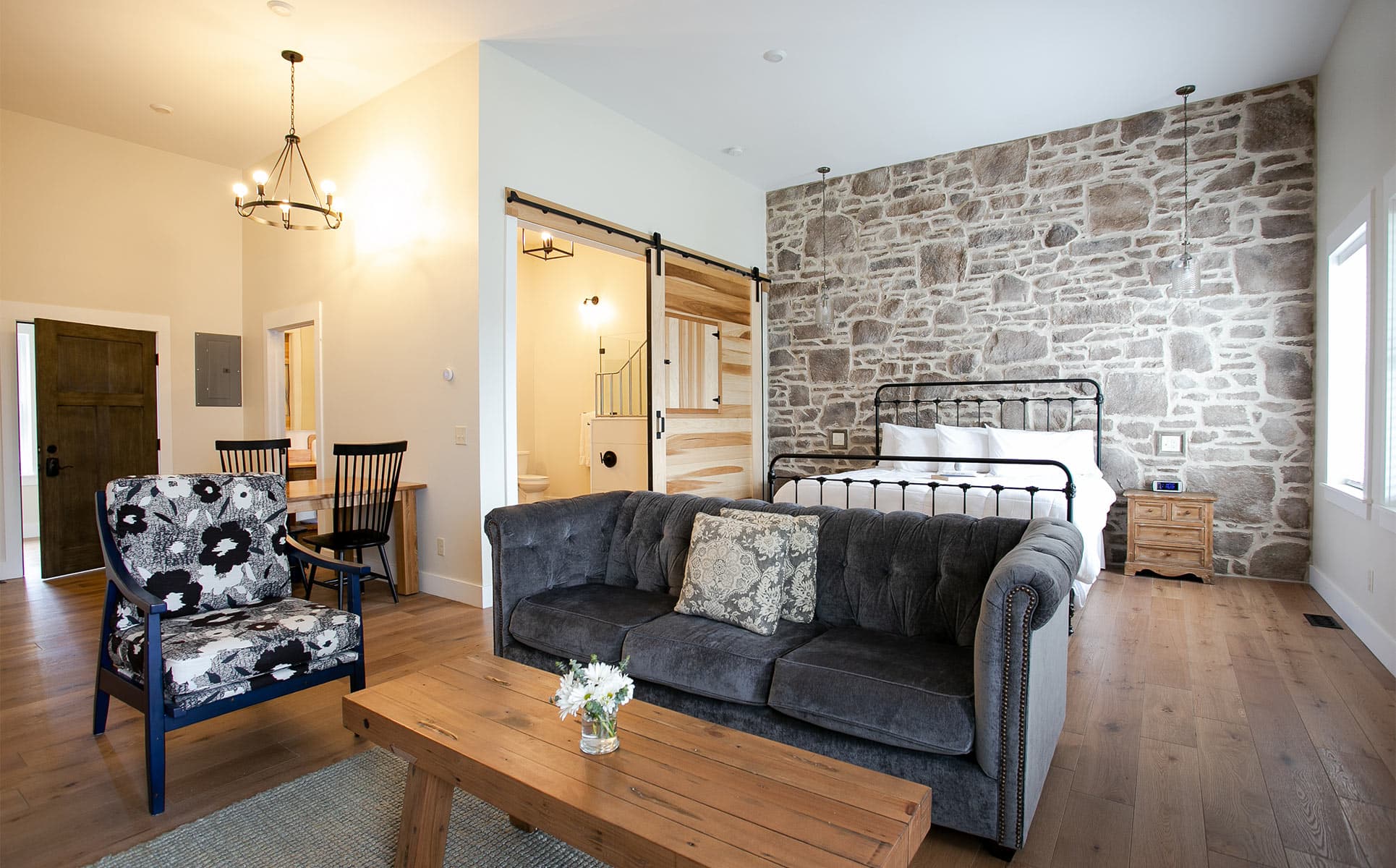 Magnolia Suite with couch, chair, and bed on stone wall