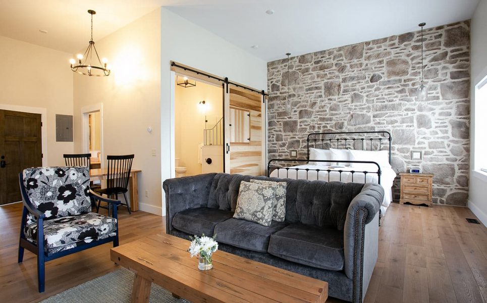 Magnolia Suite with couch, chair, and bed on stone wall