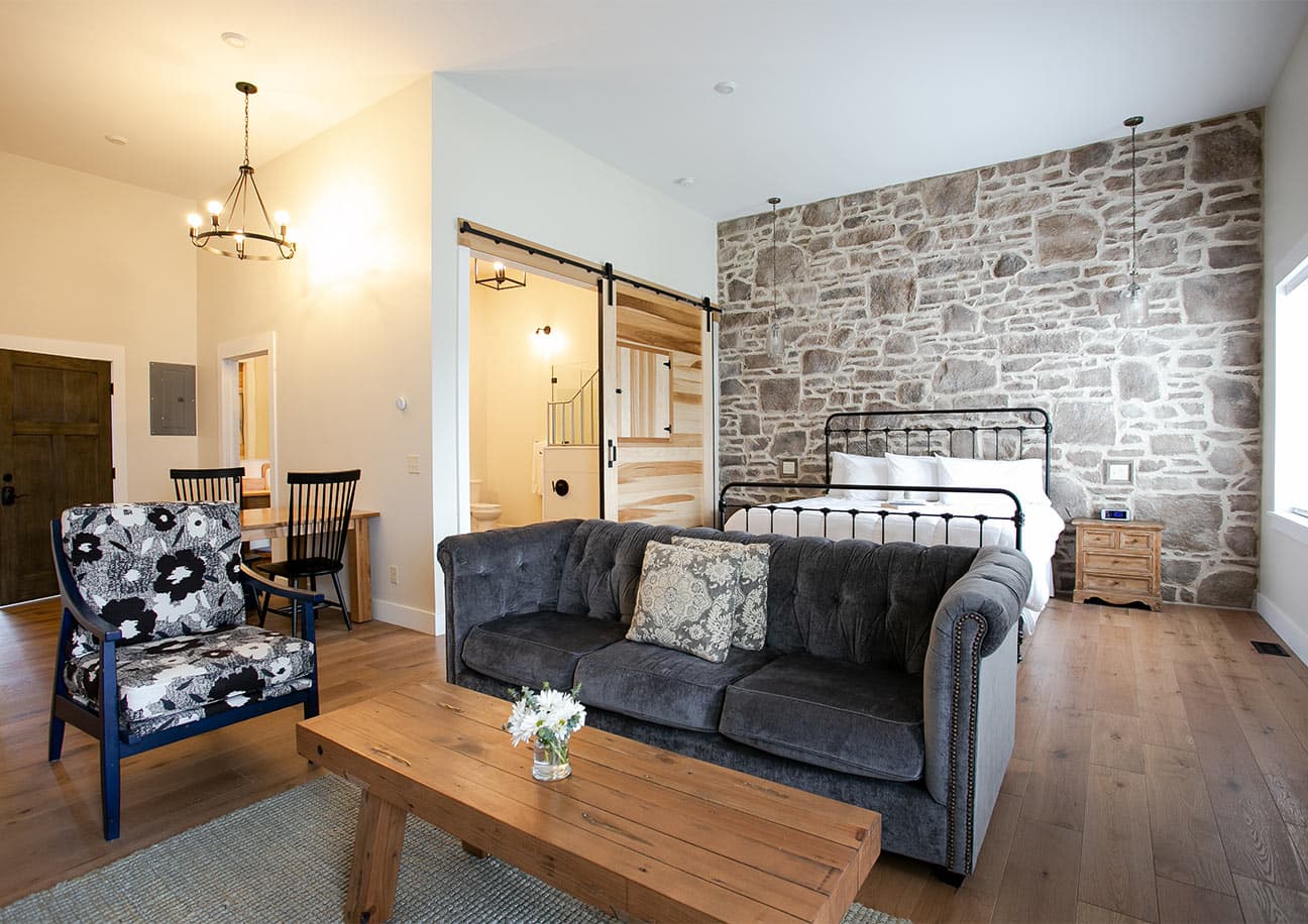 Magnolia Suite with couch, chair, and bed on stone wall