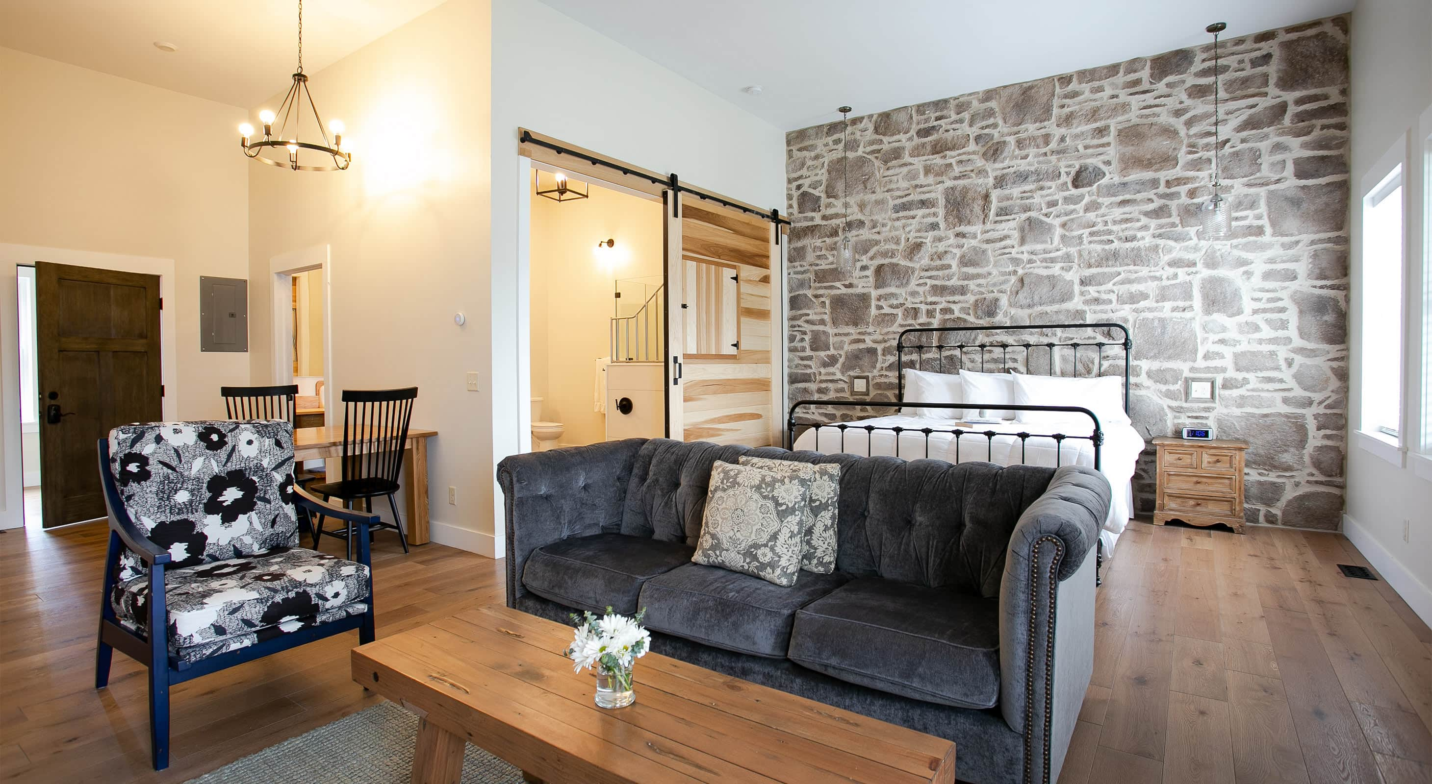 Magnolia Suite with couch, chair, and bed on stone wall