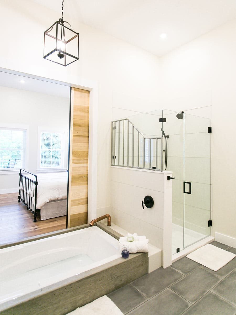 bathtub with barn door and walk-in shower