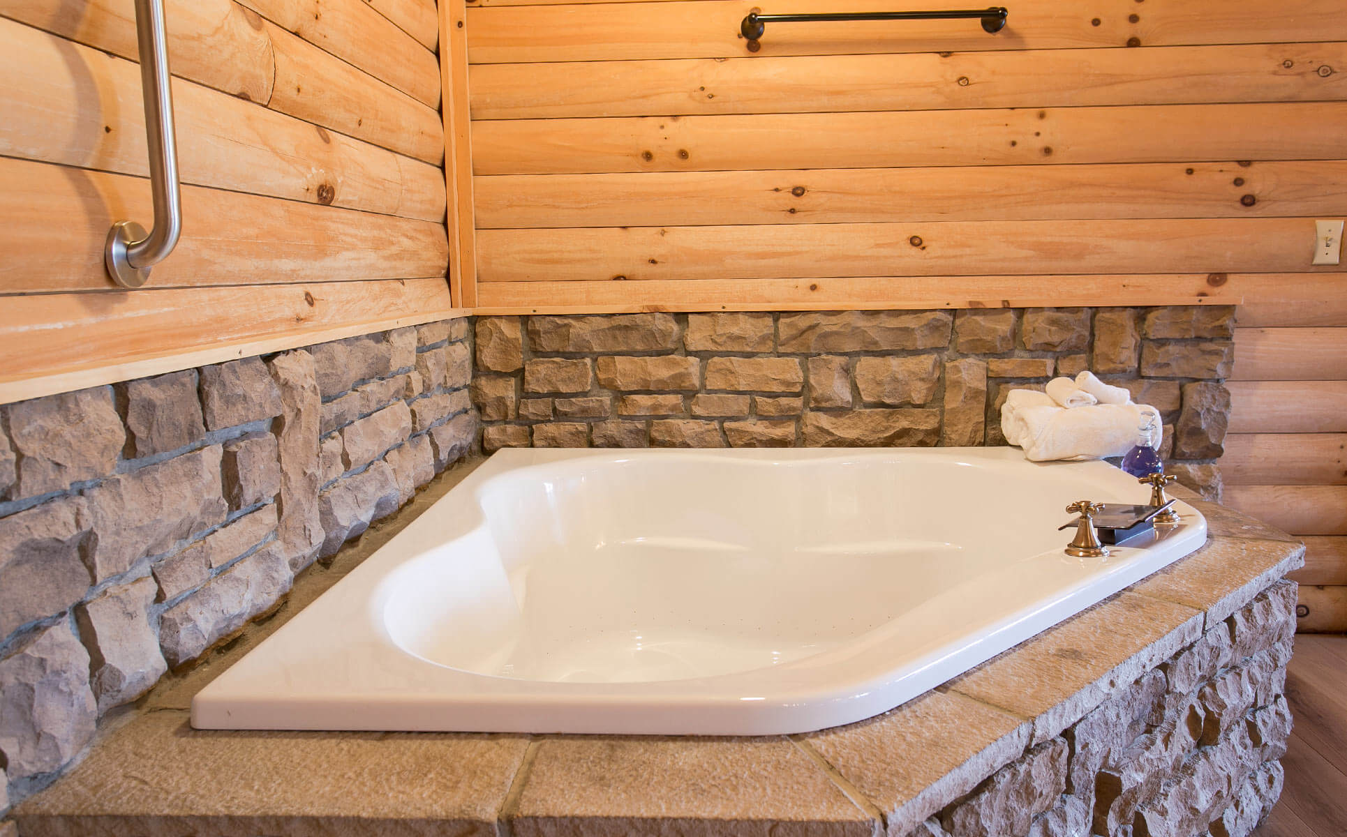 Two-person soaking tub surrounded by stone