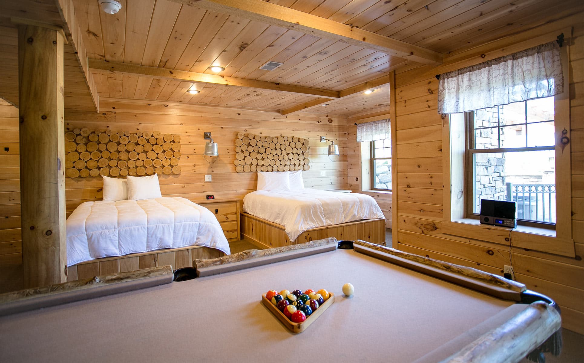 Pool Table in Basement with beds in background