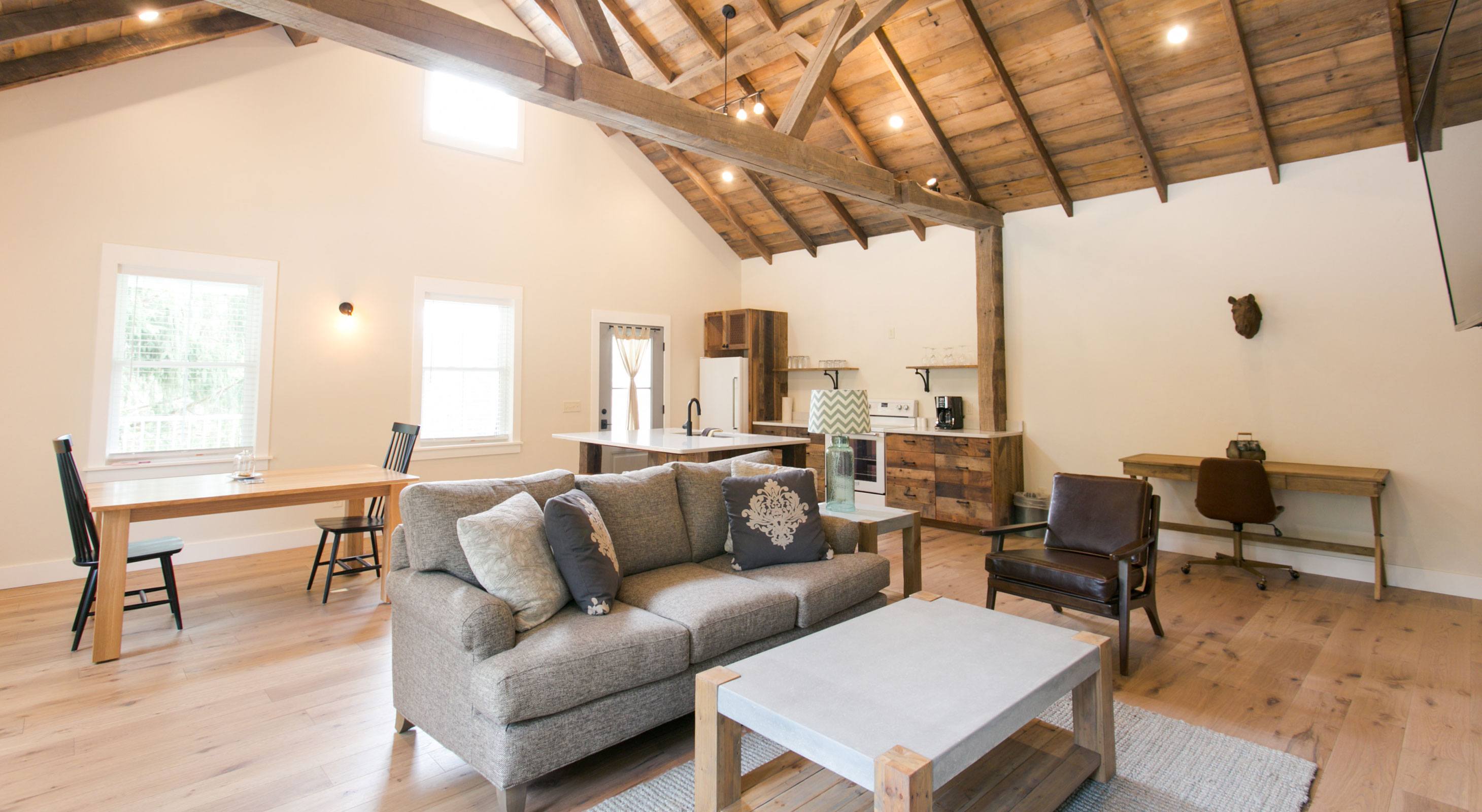 Interior of Barn Suite with couch, chair, desk, kitchen, and dining table